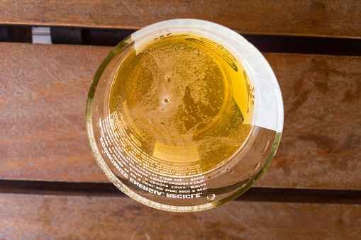 Glass of cold beer on wooden table at bar in summer. Bar on the beach. Top view of beer glass