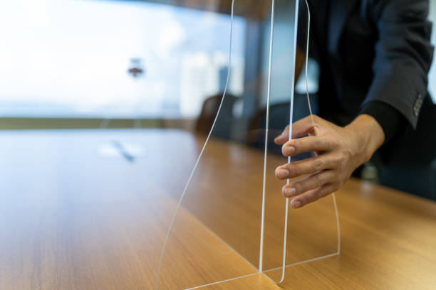 Asian businessman fixing acrylic glass on the desk stock photo