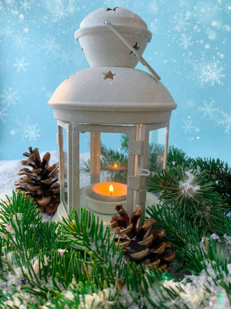 istock Snowfall winter background with candle lamp. Christmas lantern and pine tree on snow. 1289870407