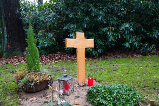 istock Wooden cross on fresh grave on german cemetery 1289871026