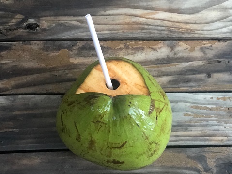Iced coconut on wooden table at the beach bar. Coconut water