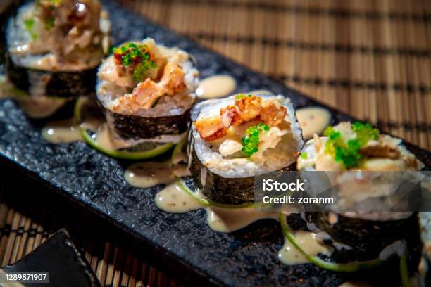 Closeup Of Sushi Rolls In Nori Lined Up On Rectangle Sushi Plate Stock Photo - Download Image Now