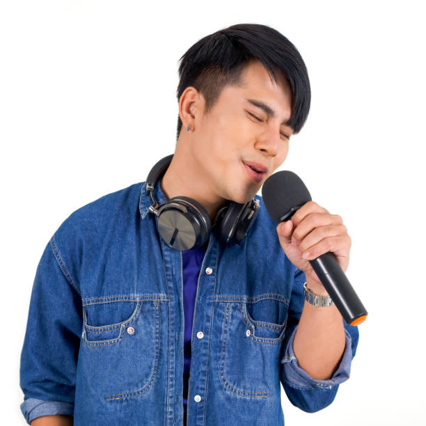 istock Young asian man in blue jean singing with microphone. Portrait on white background with studio light. Close Up 1289872329