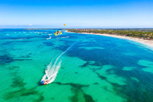 tourists parasailing near bavaro beach, punta cana in dominican republic. aerial view of tropical resort - travel the americas human age viewpoint imagens e fotografias de stock