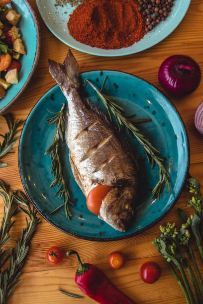 istock Fresh fish dorado. Dorado and ingredients for cooking on a table. 1289877704