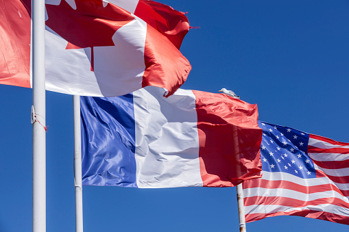 waving American, Canadian and French flags