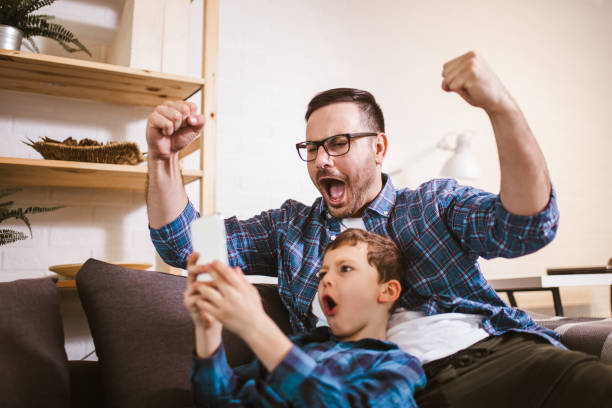 istock Father and cute little son using phone 1289884490