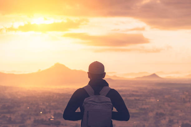 backpacker man standing at top of mountain looking view landscape with sunset sky white cloud abstract background. - climbing men sea cliff imagens e fotografias de stock