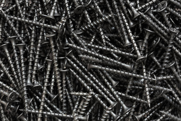 istock Pile of black self-tapping screws closeup 1289886092