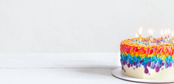 istock Colorful handmade birthday cake with burning candles copy space. 1289886702