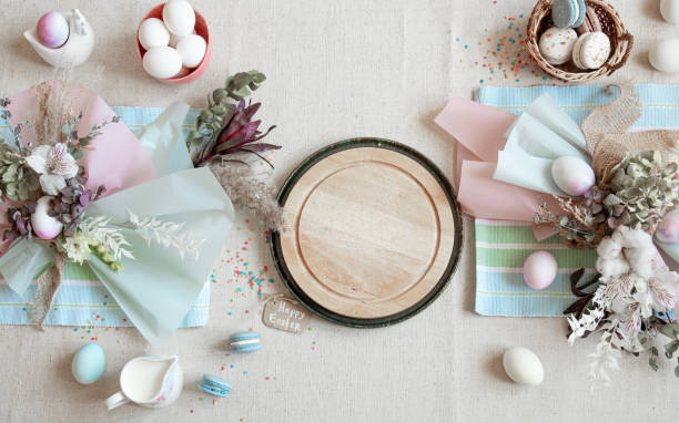 istock Easter dining table setting and decor with a wooden element in the center top view. 1289886998