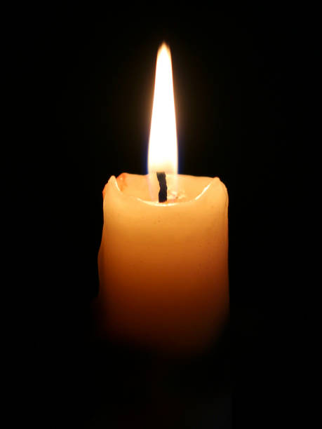 istock Burning candle on black background. Candlelight on black background 1289887739