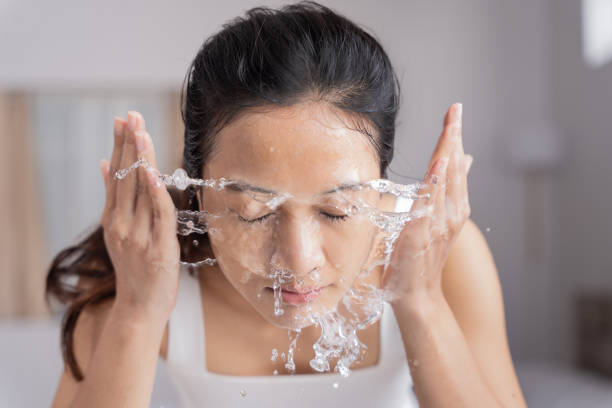 linda asiática fêmea usar água para lavar seu rosto lavar rosto. - exfoliating scrub - fotografias e filmes do acervo