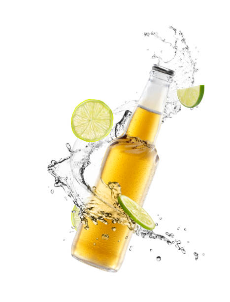 Beer splash Beer bottle with splashing liquid and lemon slice on air beer glass splash stock pictures, royalty-free photos & images