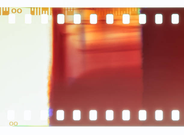 Light leak on 35mm negative film Close-up of 35mm negative photographic film, showing an abstract pattern caused by a light leak. film reel photos stock pictures, royalty-free photos & images