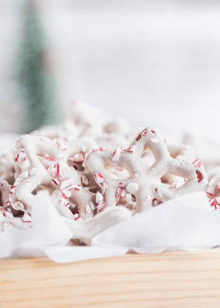 chocolate branco caseiro ou pretzels cobertos de iogurte com pedaços de bengala de doces esmagados - yoghurt coated - fotografias e filmes do acervo