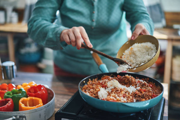 トマトソースの挽き肉でピーマンの詰め物を準備する - tomato sauce domestic kitchen meat cheese ストックフォトと画像