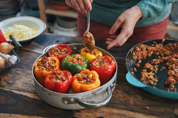 トマトソースの挽き肉でピーマンの詰め物を準備する - tomato sauce domestic kitchen meat cheese ストックフォトと画像