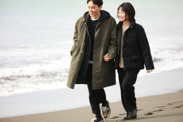 istock Couple walking on the beach 1289891768