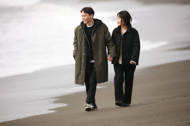 istock Couple walking on the beach 1289891898