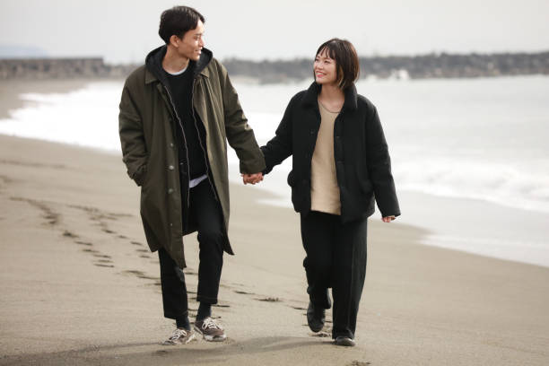 istock Couple walking on the beach 1289891975