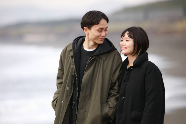 istock Couple walking on the beach 1289891999