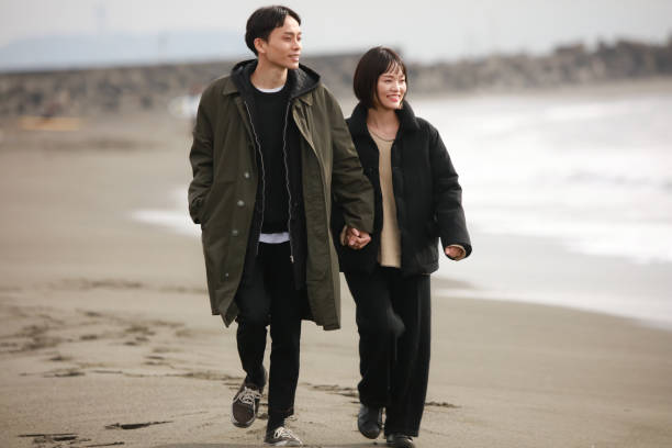 istock Couple walking on the beach 1289892036