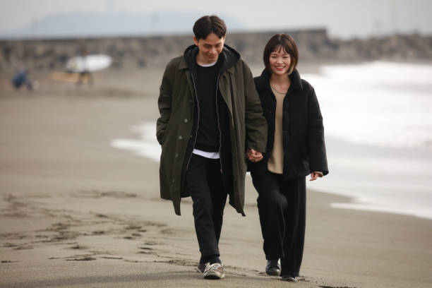 istock Couple walking on the beach 1289892047