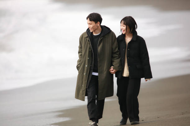 istock Couple walking on the beach 1289892159