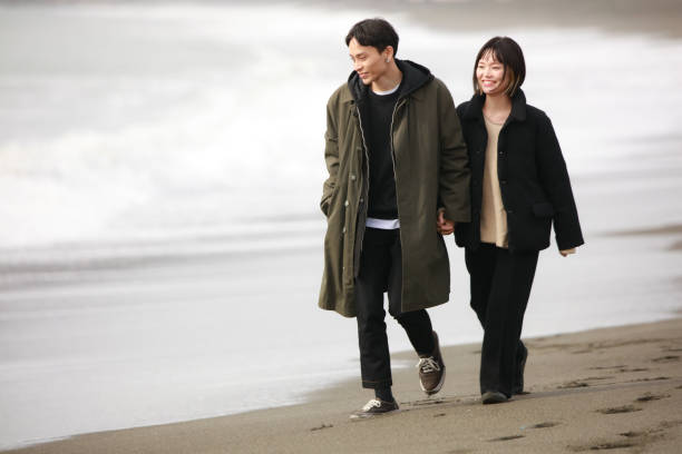 istock Couple walking on the beach 1289892195