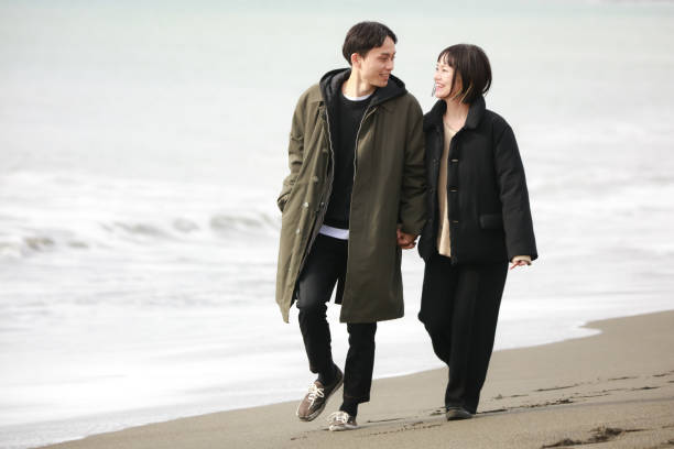 istock Couple walking on the beach 1289892855