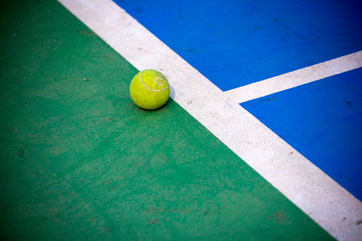 Tennis ball on tennis court background separate with red and green colour with copy space