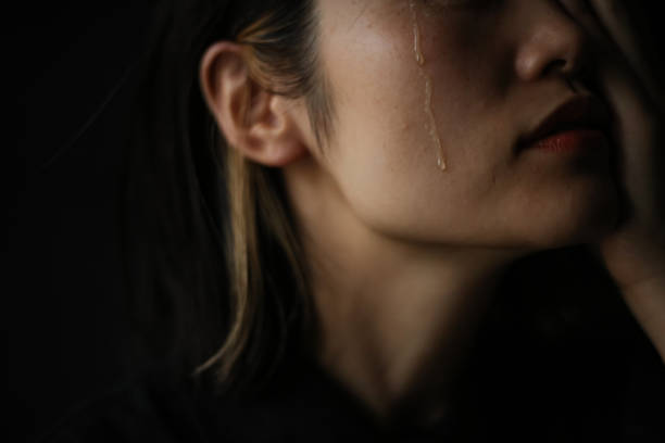 mujer derramando lágrimas - lágrima fotografías e imágenes de stock