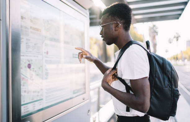 istock African American tourist with backpack looking at rout map 1289894319