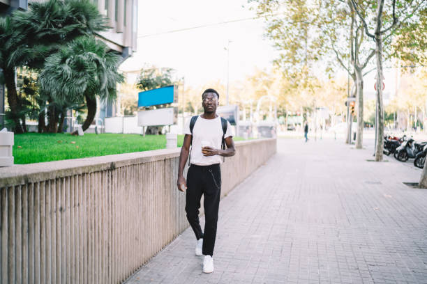 istock African American backpacker taking coffee while walking on street 1289894336