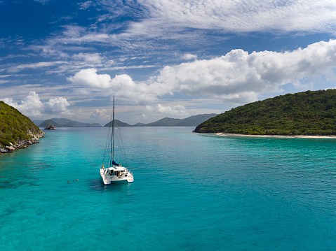 Aerial view of people relaxing and snorkeling from Catamaran at anchor outside of Lavango Cay, United States Virgin Islands