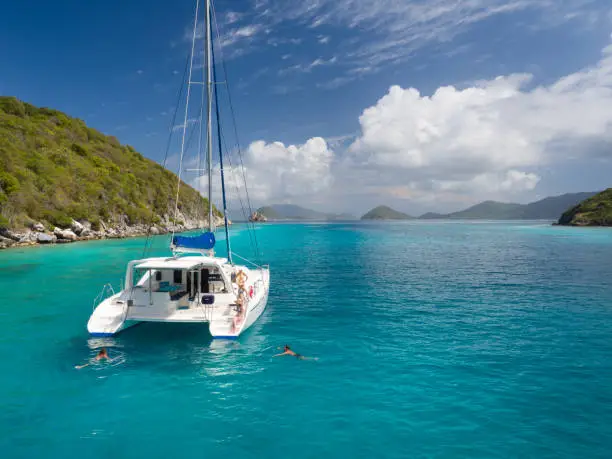 Aerial view of people relaxing and snorkeling from Catamaran at anchor outside of Lavango Cay, United States Virgin Islands