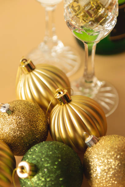 green and gold  Christmas baubles on a beige background