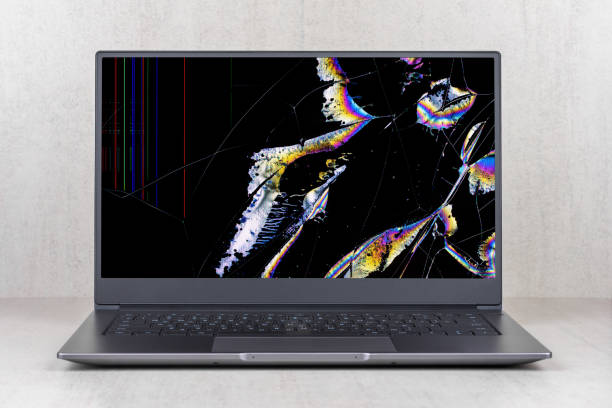 istock laptop with a broken screen in color spots and cracks on a gray background close up front view 1289895903