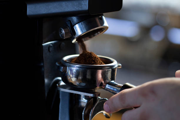 istock coffee grinder grinding coffee pouring into a portafilter 1289896123