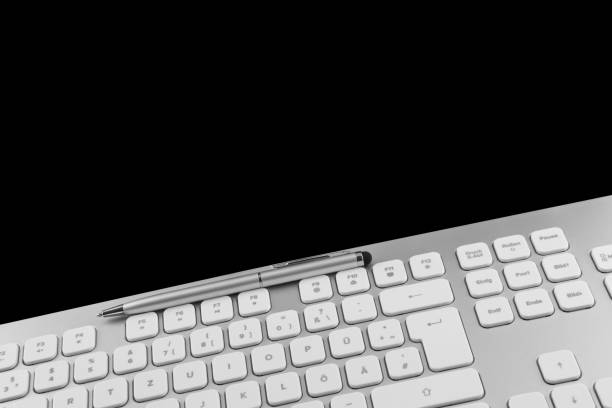 istock PC keyboard and pen against black background 1289896494