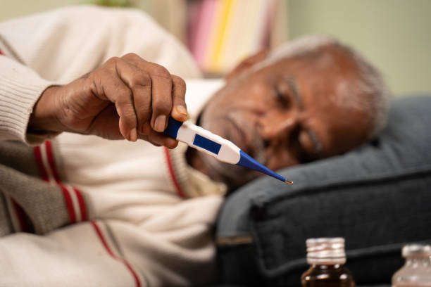 Selective focus on thermometer, sick bed ridden old man seeing temperature on thermometer. Selective focus on thermometer, sick bed ridden old man seeing temperature on thermometer covid thermometer stock pictures, royalty-free photos & images