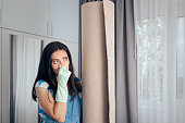 Woman Next to a Stinky Carpet Covering Her Nose