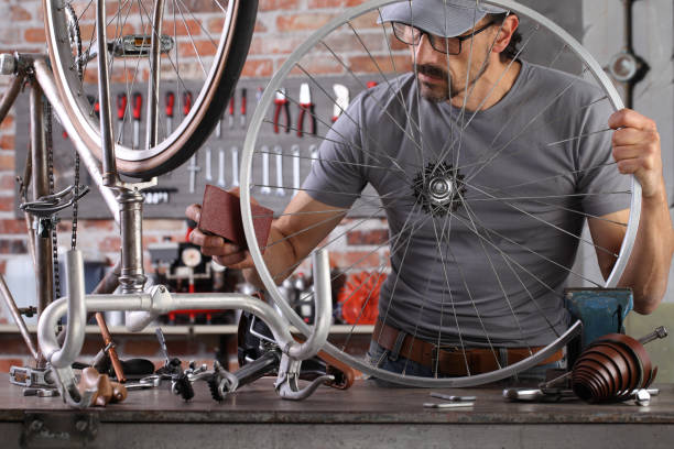 istock man repair the vintage bicycle in garage workshop on the workbench with tools, remove the rust with sand paper, diy concept 1289900233