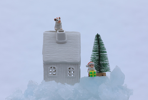 white toy christmas house and toy santa claus on ice