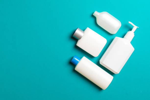 istock Set of White Cosmetic containers isolated on colored background, top view with copy space. Group of plastic bodycare bottle containers with empty space for you design 1289901924