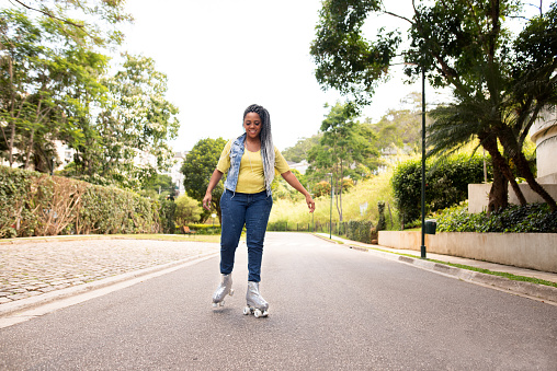Shot of a back woman, rollerblading in a street