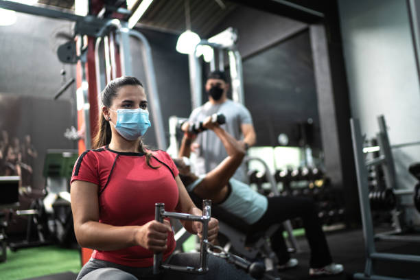 istock Young woman training in the gym - using face mask 1289906103