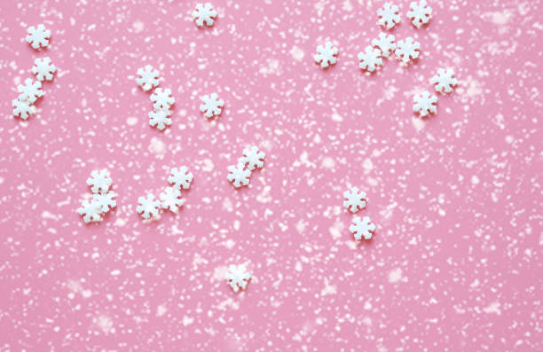 istock pink christmas background with snowflakes 1289906128