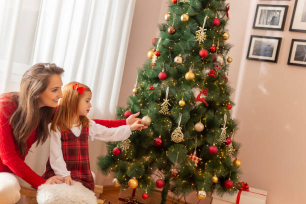 istock Mother and daughter decorating Christmas tree 1289906196